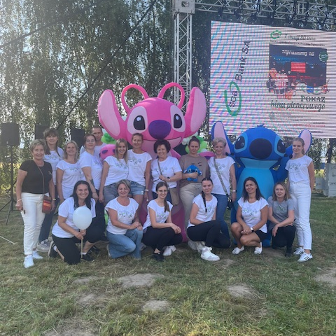 Zdjęcie grupowe pracowników banku z maskotkami Stich oraz Angel.